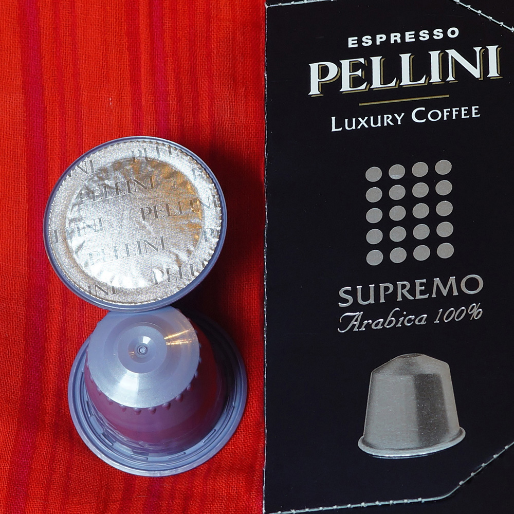 Supremo coffee capsules by Pellini Espresso - violet capsules on a red background