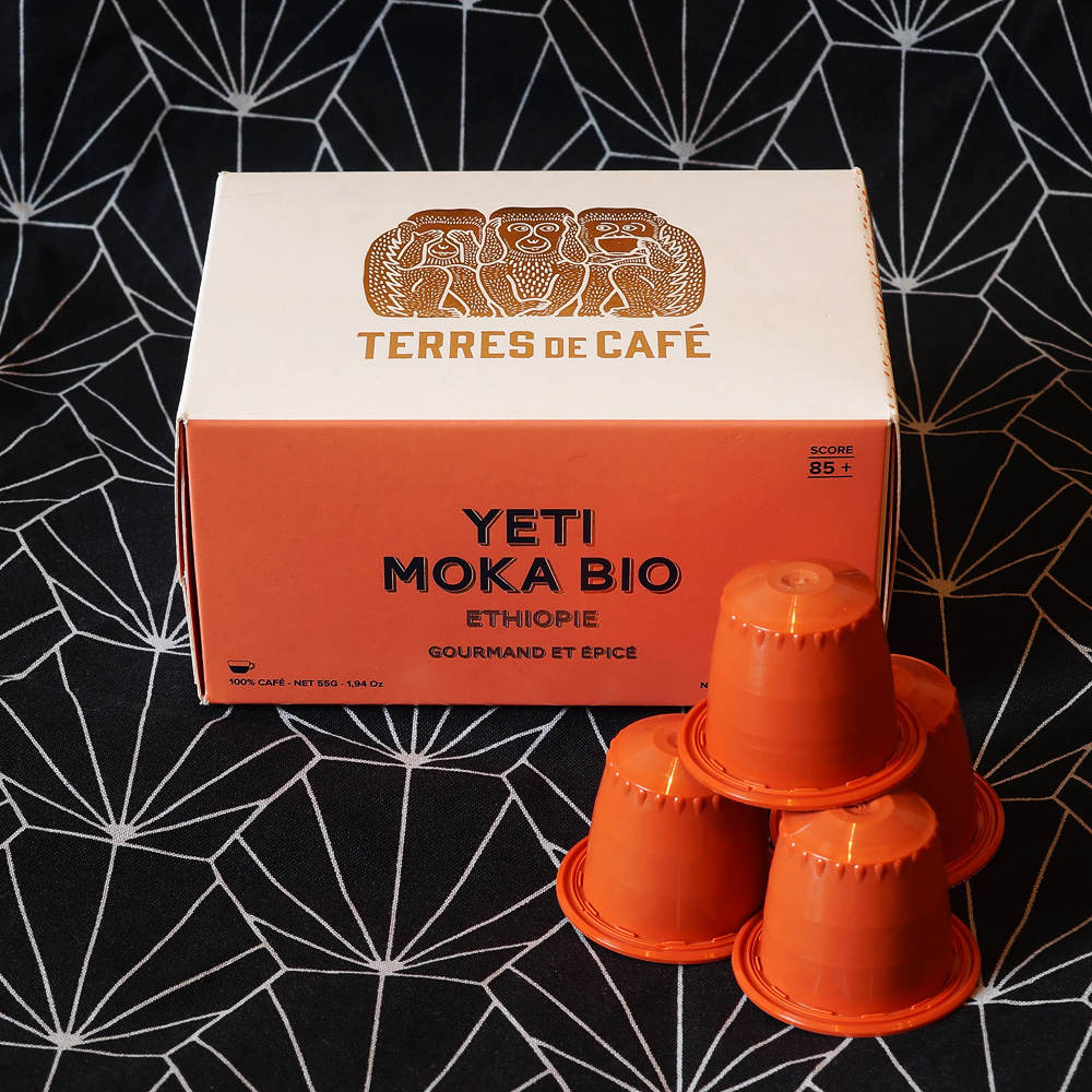 Yeti Moka Bio coffee capsules from Ethiopie by Terres de Café - orange coffee capsules with a box in a dark background