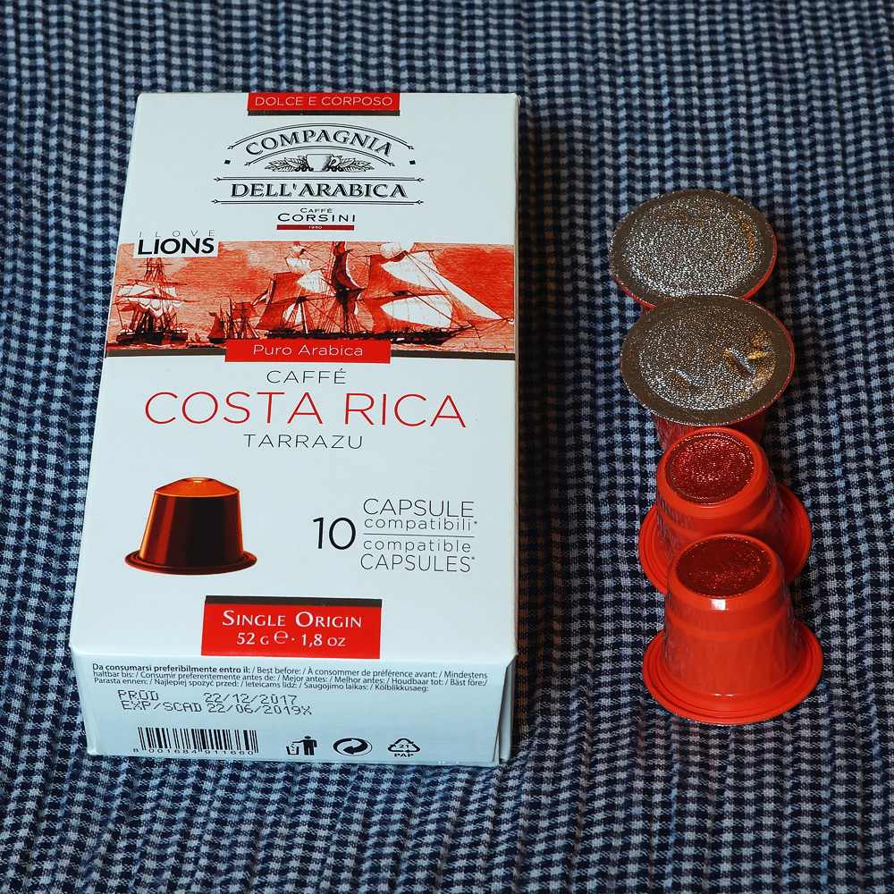 Costa Rica by Caffé Corsini - four red coffee capsules next to the box on a blue background