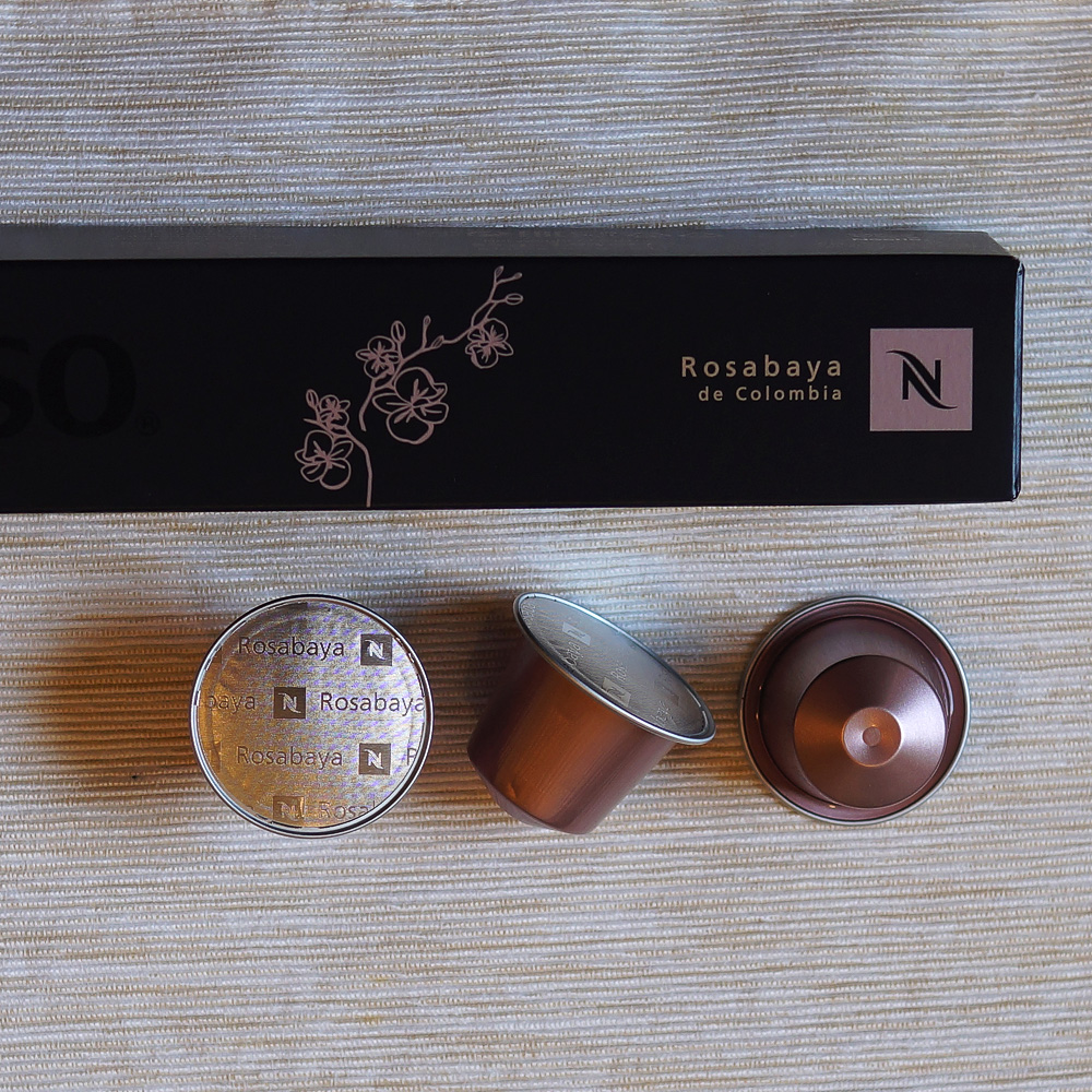 Rosabaya de Colombia by Nespresso - three pale pink capsules wuth black packinging box on light backgound