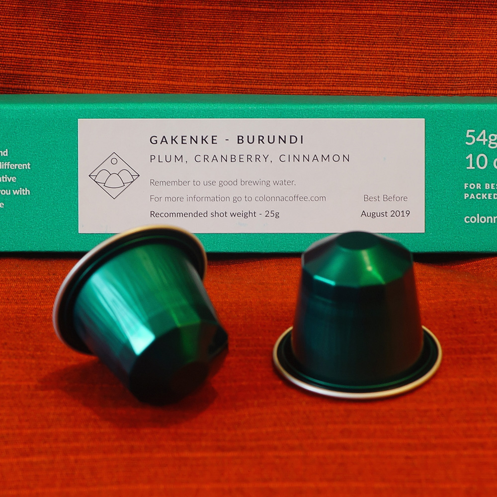 Gakenke by Colonn - two green coffee capsules and a green box on a red background