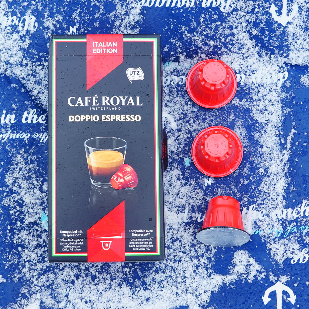 Doppio Espresso by Café Royal - three red coffee capsules and a box on a blue background