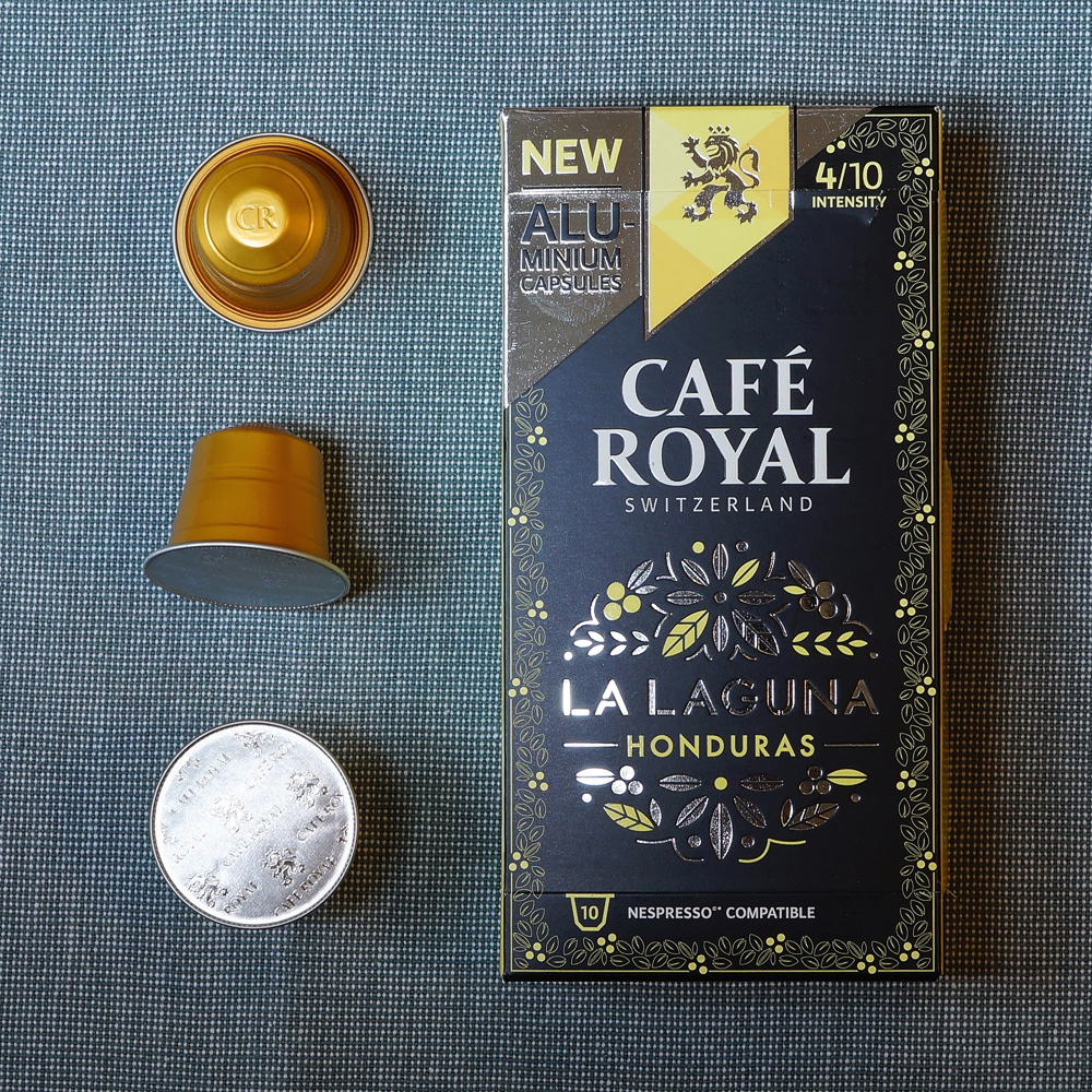 Cafe Royal coffee box with three golden coffee capsules on the side