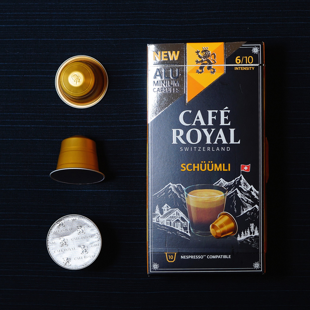 Cafe Royal coffee capsule box with 3 coffee pods on dark background